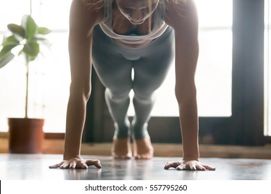 Young Attractive Woman Practicing Yoga, Standing In Push Ups, Press Ups, Phalankasana Exercise, Plank Pose, Working Out, Wearing Sportswear, Grey Pants, Bra, Indoor, Home Interior Background. Close Up
