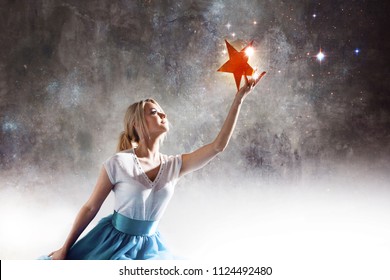 Young Attractive Woman Reaching For The Star. Take A Star From The Sky, Dreams And Plans, Concept. Textured Gray Background