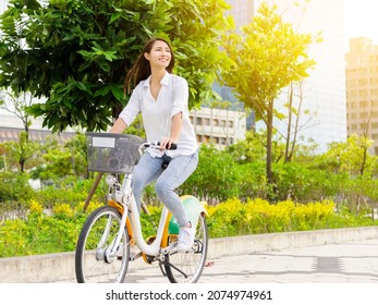 Young attractive woman riding  bicycle in the city park - Powered by Shutterstock