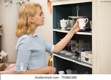 Young Attractive Woman Shopping For Dinnerware At The Local Store Examining Ceramic Cup Smiling Joyfully Copyspace Home Coziness Decor Buyer Shopper Shopaholic Consumerism Retail Purchase Designer