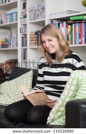 Similar – Happy girl using a smart phone sitting on a couch at home