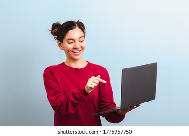 Young Attractive Woman Student With Funny Face Holding A Laptop And Pointing Into It Applaying For University Or College Enrolment