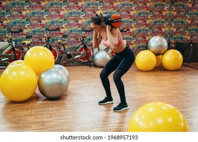 Young Attractive Woman Training In The Gym While Carrying A Sandbag On Her Shoulders