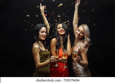Young attractive women celebrating a party, drinking champagne and dancing