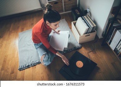 Young Audiophile Playing Vinyl Record On Turntable From At Her Home. Enjoy Vinyl Records