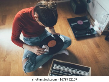 Young Audiophile Sitting On Floor And Cleaning Dust Form Her Vinyl Record Collection