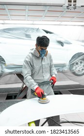 Young Auto Mechanic Man Buffing And Polishing Car Holding Polisher In Hand, In Repair Shop. Renew Service Station Shop By Power Buffer Machine