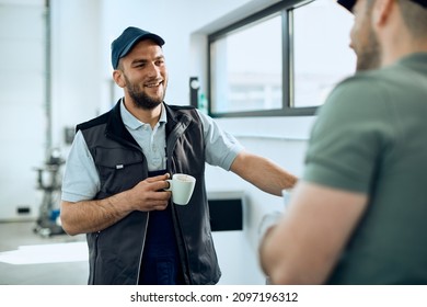 Young auto repair man drinking coffee and communicating with a colleague in a workshop. - Powered by Shutterstock