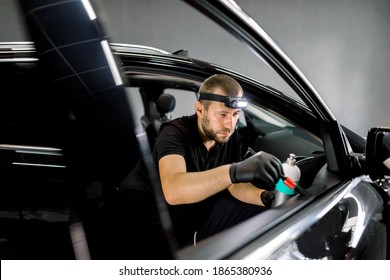 Young Auto Service Station Male Worker, Wearing Uniform And Gloves, Making Cleaning And Care Procedure For Leather And Plastic Parts Of Car Door Interior, Using Brush And Special Milk