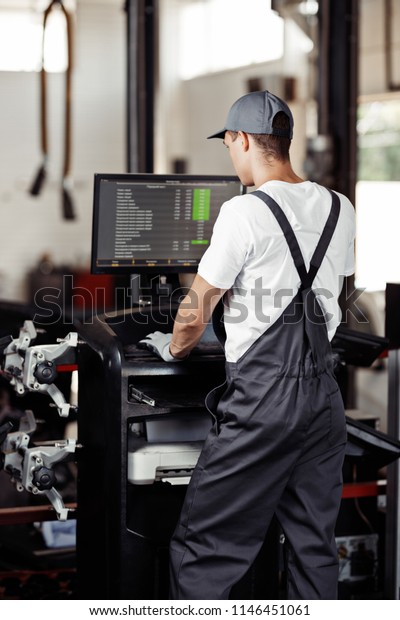 A young automechanic is seacrhing for bugs during the\
procedure 