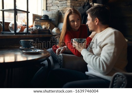 young awesome lady putting her arms on her boyfriend's shoulder and listening to his compliments, close up photo.couple sharing with secrets. close up side view photo