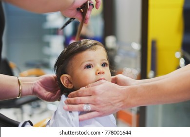 Young baby boy at hairdresser cutting his hair