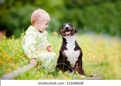 Young Baby Boy With A Puppy Outdoors