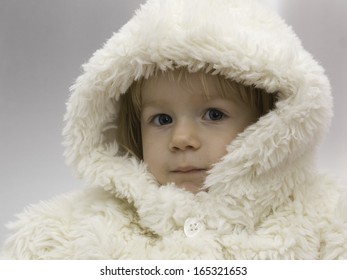 Young Baby Girl Wearing A White Snowsuit