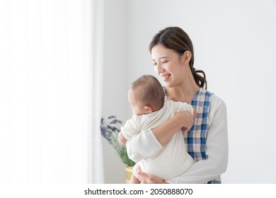 Young Babysitter Hugging A Baby