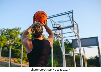 Young back view sporty strong sportsman man 20s wearing sports clothes training scoring basket shooting free throw play with ball at basketball game playground court Outdoor courtyard sport concept. - Powered by Shutterstock