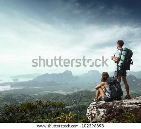 Young backpackers enjoying a valley view from top of a mountain