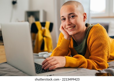 Young Bald Female Laying In Her Room And Using Laptop Computer