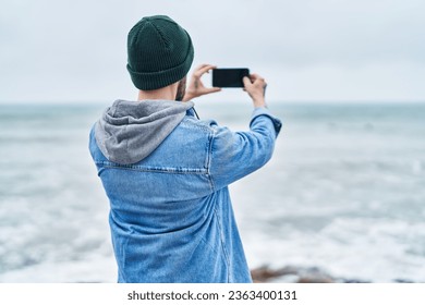 Young bald man make photo by smartphone at seaside - Powered by Shutterstock