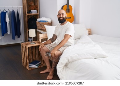 Young Bald Man Smiling Confident Sitting On Bed At Bedroom