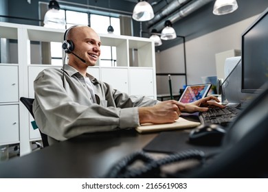 Young Bald Man Working In A Call Center Office