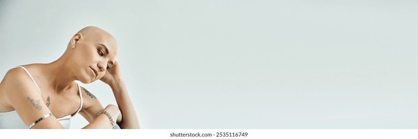 A young bald woman thoughtfully gazes downward, showcasing her unique beauty. - Powered by Shutterstock