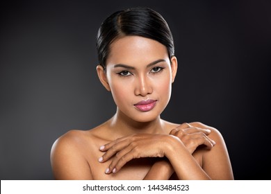 
Young Balinese woman touching her skin, spa beauty over black 