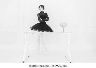 a young ballerina in a black tutu standing at a table listening to music with headphones, business style, total black - Powered by Shutterstock