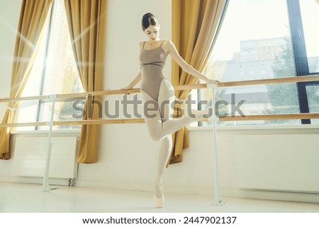 a young ballerina in a dance class at a ballet machine does stretching and classical exercises