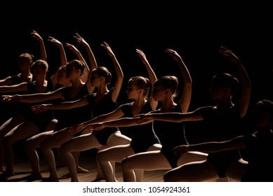 Young Ballerinas Practicing A Choreographed Dance All Raining Their Arms In Graceful Unison During Practice At A Ballet School