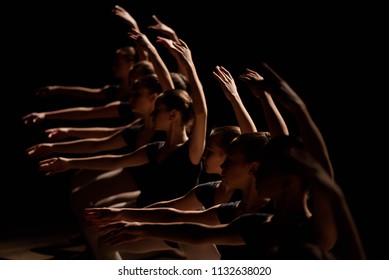 Young Ballerinas Practicing A Choreographed Dance All Raining Their Arms In Graceful Unison During Practice At A Ballet School