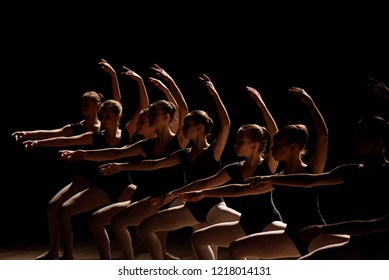 Young Ballerinas Practicing A Choreographed Dance All Raining Their Arms In Graceful Unison During Practice At A Ballet School