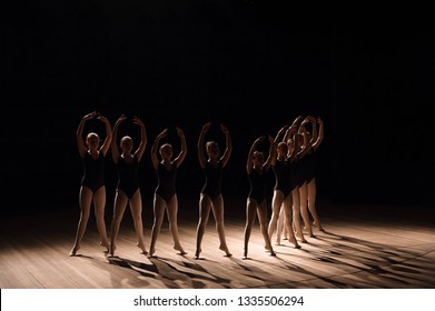 Young Ballerinas Practicing A Choreographed Dance All Raining Their Arms In Graceful Unison During Practice At A Ballet School