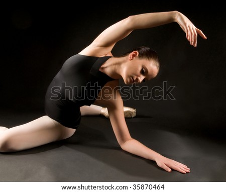 Young ballet dancer posing and stretching on the floor