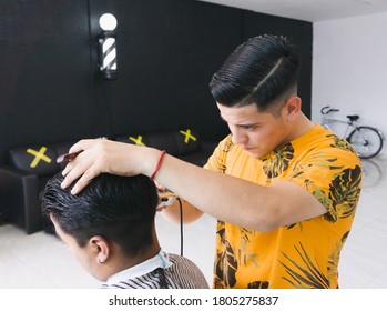 Young Barber Cutting Hair In Barbershop