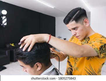 Young Barber Cutting Hair In Barbershop