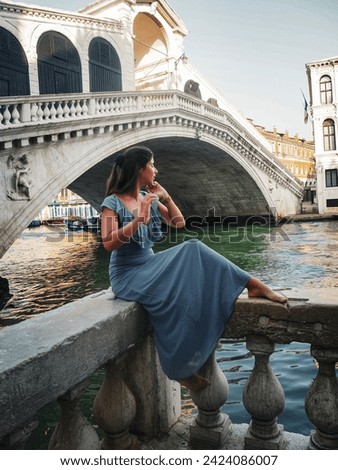 Young barefoot woman in dress in front of the Rialo Bridge in Venice