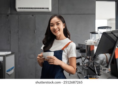 Young Barista Making Coffee in Modern Cafe, Smiling Female Barista Holding Cup, Professional Coffee Making, Barista at Work, Coffee Shop Interior - Powered by Shutterstock