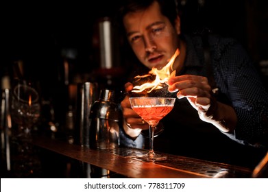 Young Barman Making A Fresh Alcoholic Cocktail With A Smoky Note On The Bar Counter