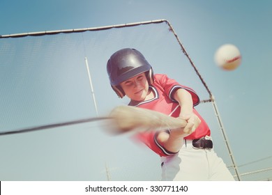 Young baseball player hitting the ball.  Vintage instagram effect, motion blur on bat and ball