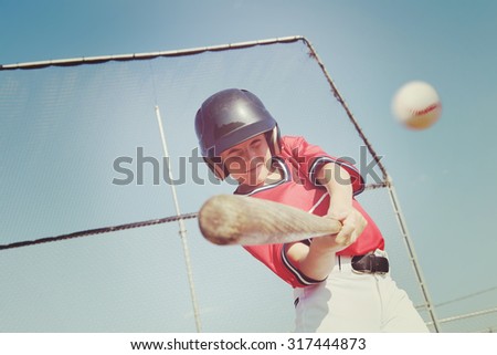 Young baseball player hitting the ball.  Vintage instagram effect