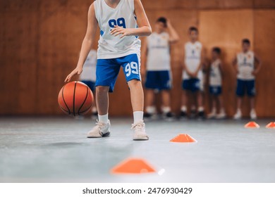 A young basketball player with the ball during a training session, highlighting the essence of youth sport and skill development - Powered by Shutterstock