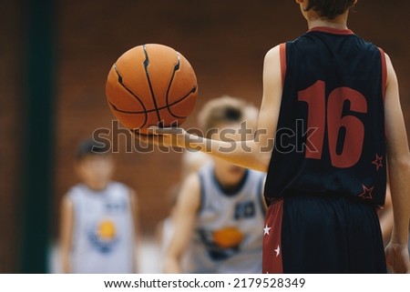 Young basketball player with classic ball. Junior level basketball player holding game ball. Basketball training session for kids