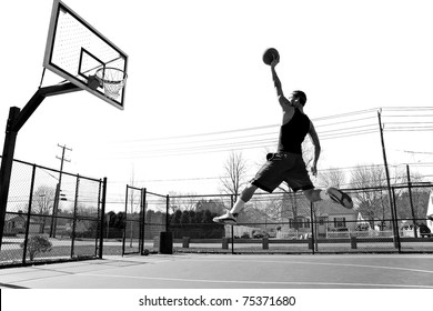 A young basketball player flying towards the rim for a slam dunk. - Powered by Shutterstock