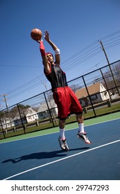 A Young Basketball Player Shooting A Three Point Jump Shot.