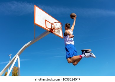 Young Basketball Street Player Making Slam Dunk