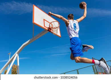 Young Basketball Street Player Making Slam Dunk