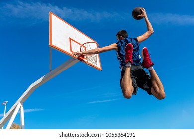 Young Basketball street player making slam dunk - Powered by Shutterstock