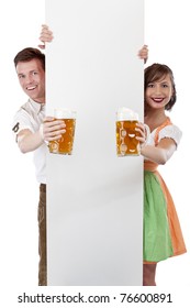 Young Bavarian man and girl in dirndl with ad space and beer stein. Isolated on white background.