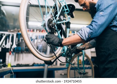 Young beard bicycle mechanic repairing bicycles in a workshop.	 - Powered by Shutterstock